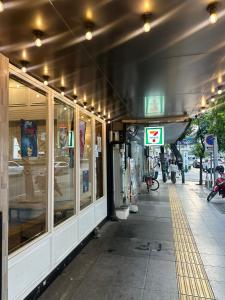 a store front of a building with windows and a sidewalk at The poshtel Bangkok By Benya BTS Phayathai in Bangkok