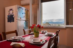 a kitchen table with a red tablecloth and a refrigerator at La Playa di Ponente in Cagliari