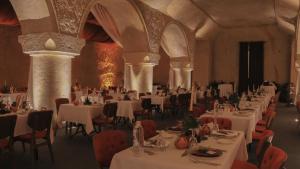 a dining room with white tables and chairs in a building at Yunak Evleri Cappadocia in Urgup