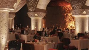 a banquet hall with white tables and chairs at Yunak Evleri Cappadocia in Urgup