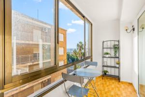 Una habitación con una mesa y una ventana grande. en Unique Apartahotel 4-2, en Torrevieja