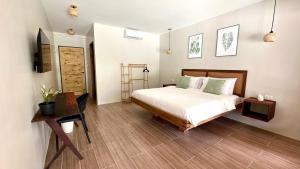 a bedroom with a bed and a wooden floor at Aulea Siargao in General Luna