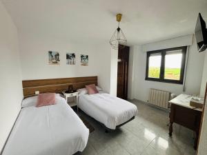 Un dormitorio con dos camas y un escritorio y una ventana. en Hospedaje Galizano, en Galizano
