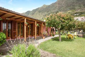 a house with a table and a tree in the yard at Casa Elvira Hermigua in Hermigua
