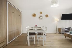 ein weißes Esszimmer mit einem weißen Tisch und Stühlen in der Unterkunft Un Havre De Paix in Fréjus