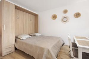 ein Schlafzimmer mit einem Bett, einem Schrank und einem Schreibtisch in der Unterkunft Un Havre De Paix in Fréjus