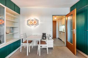 Über den Wolken في هوتشنشوند: مطبخ صغير مع طاولة بيضاء وكراسي