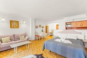 una sala de estar con una cama y un sofá en Unique Apartahotel 3-3, en Torrevieja