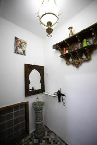 een kamer met een open haard en een kroonluchter aan de muur bij Dar El Kendil in Fès
