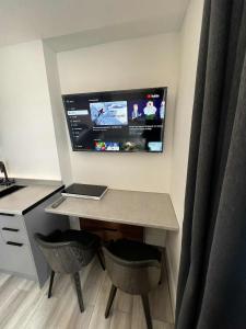 een bureau met een laptop en een tv aan de muur bij Resilets - Mood Studio 2 - Central Modern 2 Bed in Bedlington