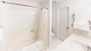 Club Villas Unit 2B في صن سيت بيتش: حمام أبيض مع دش ومرحاض +7 صور