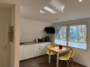 a kitchen with a table and chairs and a window at Abseits vom Alltag, Finnhütte umgeben von Wald und frischer Luft - Fiete in Trassenheide +13 photos