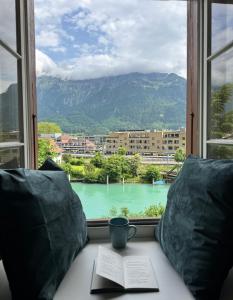 a coffee cup sitting on a table in front of a window at River-2 with Iconic Jungfraujoch View in Interlaken