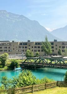 a bridge over a river with buildings in the background at River-2 with Iconic Jungfraujoch View in Interlaken
