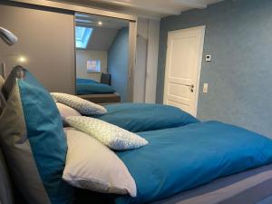 Ferienwohnung im Gulfhof, 65269 في Moormerland: غرفة نوم بسريرين مع ملايات ووسائد زرقاء