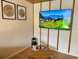 a living room with a tv hanging on a wall at River-2 with Iconic Jungfraujoch View in Interlaken +29 photos
