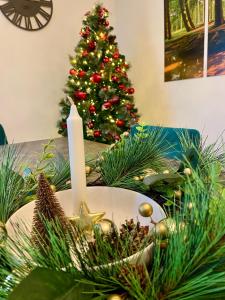 a christmas table with a candle and a christmas tree at Traumhaus Wernigerode mit Sauna und Kamin in Wernigerode