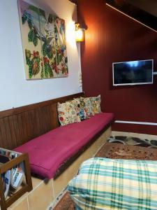 Una habitación con un sofá morado y una cama. en Gitavesnois - 4910 -, en Willies