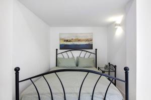 Un dormitorio con una cama negra con un cuadro en la pared. en Mi Casa Es Su Casa Nº2, en Albufeira