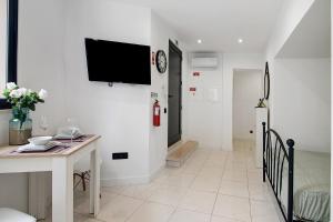 Una sala de estar con una mesa y un televisor en una pared. en Mi Casa Es Su Casa Nº2, en Albufeira