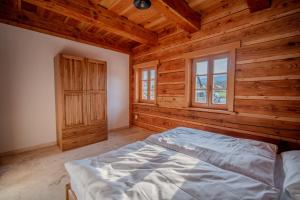 a bedroom with a bed in a wooden room at Roubenka za Horou in Orlické Záhoří  +68 photos