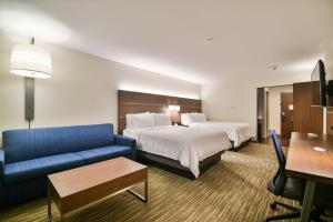 een hotelkamer met twee bedden en een blauwe bank bij Holiday Inn Express & Suites Lehi - Thanksgiving Point by IHG in Lehi +53 foto's