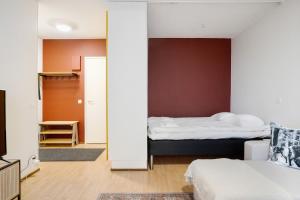 a bedroom with two beds and a room with a mirror at Cozy Studio, Free Parking By Lapland Host in Rovaniemi