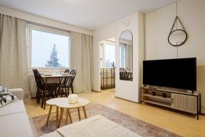 a living room with a television and a table with chairs at Cozy Studio, Free Parking By Lapland Host in Rovaniemi
