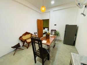 a living room with a table and a refrigerator at Sea Path Villa - Dikwella in Dickwella