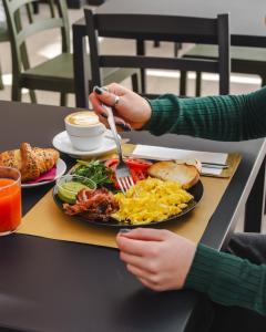 una persona che mangia un piatto di prodotti per la colazione su un tavolo di Fico! Apartments by MONHOLIDAY a Monopoli