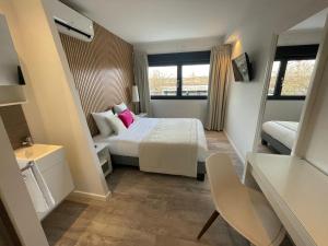 a small bedroom with a bed and a window at Hôtel les Coulisses in Forbach