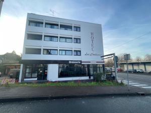 a large white building on the side of a street at Hôtel les Coulisses in Forbach