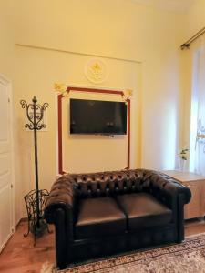 a leather couch in a living room with a flat screen tv at Theodoros Kolokotronis - Amfitriti in Nafplio