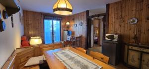 a kitchen with wooden walls and a table in a room at Casa Vaiolet in Pozza di Fassa
