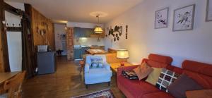 a living room with a red couch and a blue chair at Casa Vaiolet in Pozza di Fassa +29 photos