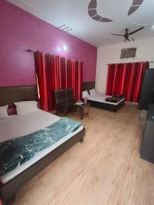 ein Schlafzimmer mit zwei Betten und roten Vorhängen in der Unterkunft Treat Hotel And Restaurant in Naimishāranya + 2 Fotos