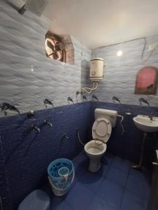 ein Badezimmer mit Toilette und Waschbecken in der Unterkunft Treat Hotel And Restaurant in Naimishāranya
