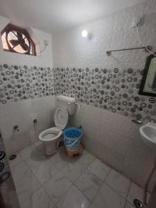 ein Badezimmer mit Toilette und Waschbecken in der Unterkunft Treat Hotel And Restaurant in Naimishāranya