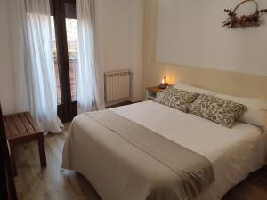 a bedroom with a large white bed and a window at Alojamiento Rural Tres Palacios in Molina de Aragón