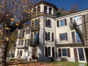 a large white house with a clock tower at La Quiete del Mattino in Torre Pellice