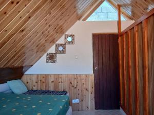 Paraiso das ilhas في Ribeirão Chiqueiro: غرفة نوم بسرير في سقف خشبي