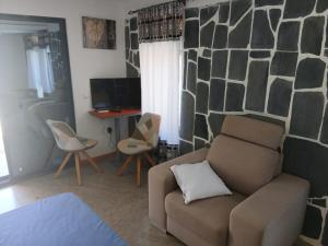 Paraiso das ilhas في Ribeirão Chiqueiro: غرفة معيشة بها أريكة ومكتب