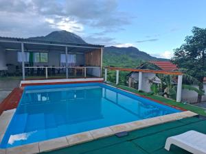 Paraiso das ilhas في Ribeirão Chiqueiro: مسبح في فيلا فيها جبال في الخلف