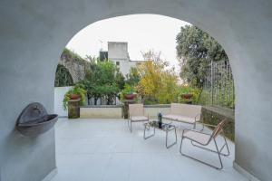 an archway with chairs and tables on a patio at L'Appoggio in Castellammare di Stabia