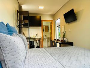 a bedroom with a bed and a bathroom with a sink at Pousada Maritimus in Barretos +47 photos