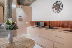 a kitchen with a table and a clock on the wall at L'Appoggio in Castellammare di Stabia