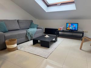 Una sala de estar con un sofá y una mesa de café. en Atico Finisterre, en Finisterre