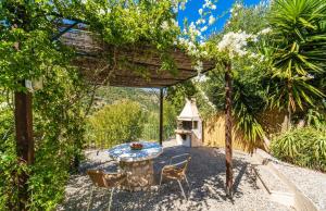 un patio con tavolo e sedie sotto un pergolato di Arethusa Cottage a Vathi Altre 6 foto