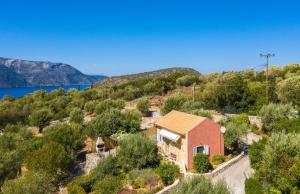 una vista aerea di una piccola casa con alberi e un lago di Arethusa Cottage a Vathi