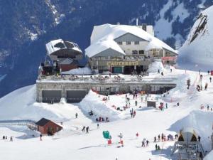 Un groupe de personnes dans la neige devant un bâtiment dans l'établissement Studio cosy 4 pers au cœur de Cauterets - FR-1-234-146, à Cauterets